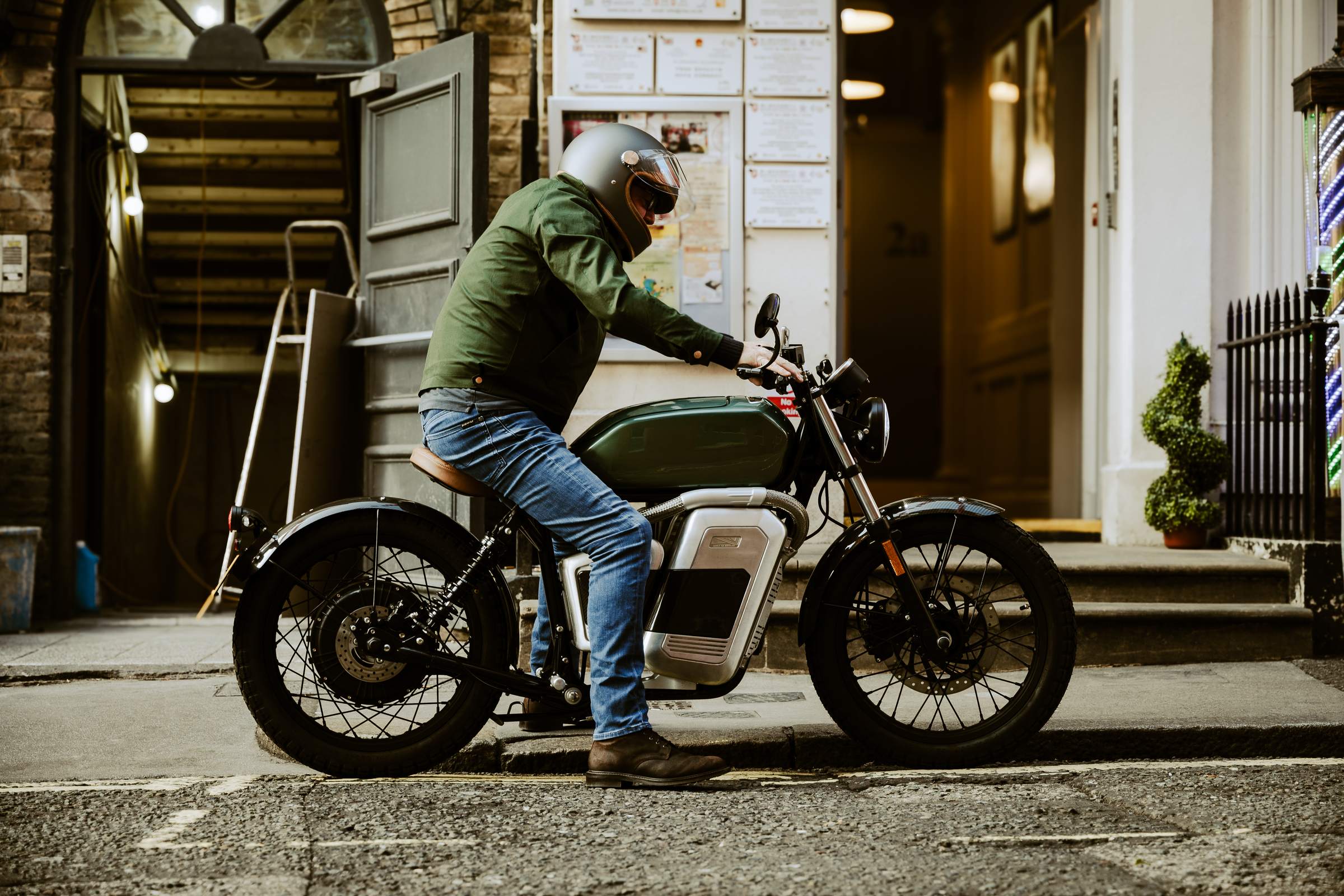 Motard au guidon d’une moto électrique dans une rue de centre-ville